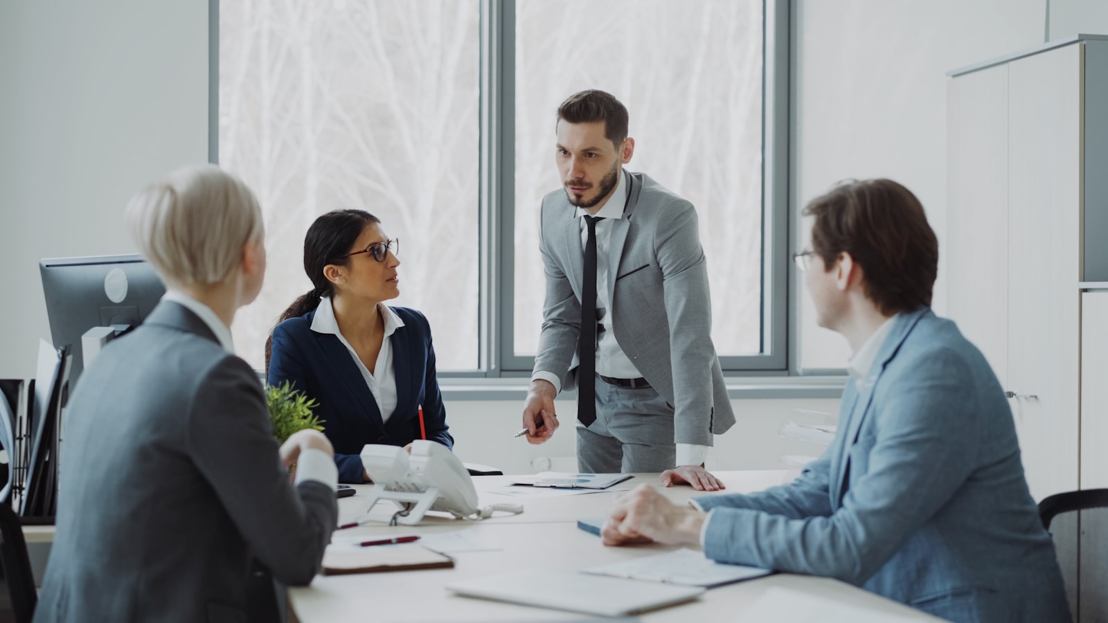 Team reviewing compliance documentation in an office meeting